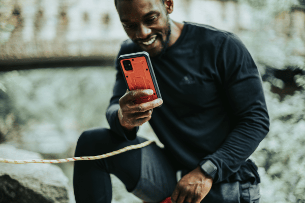 a outdoor man climbing using his phone in tactical phone case